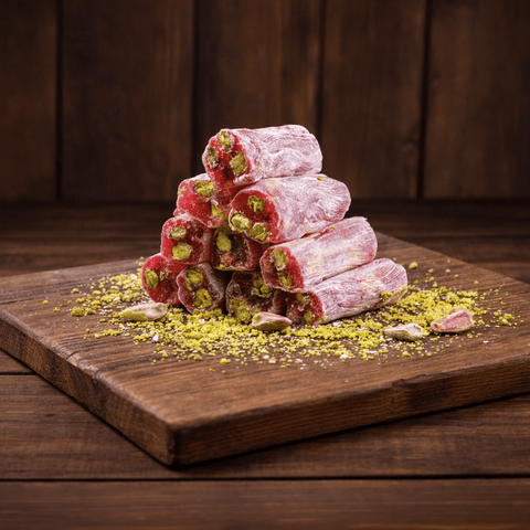 Narlı Antep Fıstıklı Sultan Fitil Lokum 1000g stacked on a wooden board with crushed pistachios.