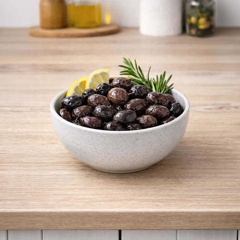 Yağlı Sele Siyah Zeytin İri Boy ( Manisa Akhisar ) 700g, aromatic black olives in a bowl with lemon.